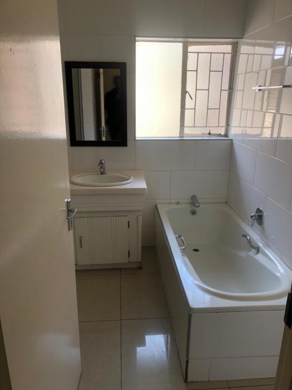 范德拜尔帕克The Coastal Guesthouse的白色的浴室设有浴缸和水槽。