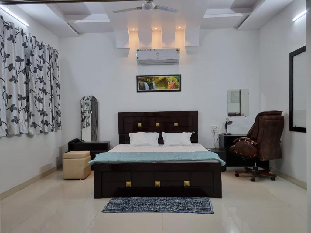 贾巴尔普尔Leela Homestay Jabalpur - Lily - 2 BHK Luxury appartment的一间卧室配有一张床、一张桌子和一把椅子