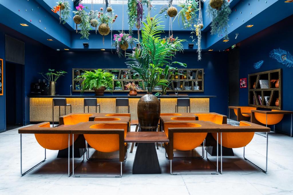 巴黎1K Paris的一间设有橙色桌椅和蓝色墙壁的餐厅