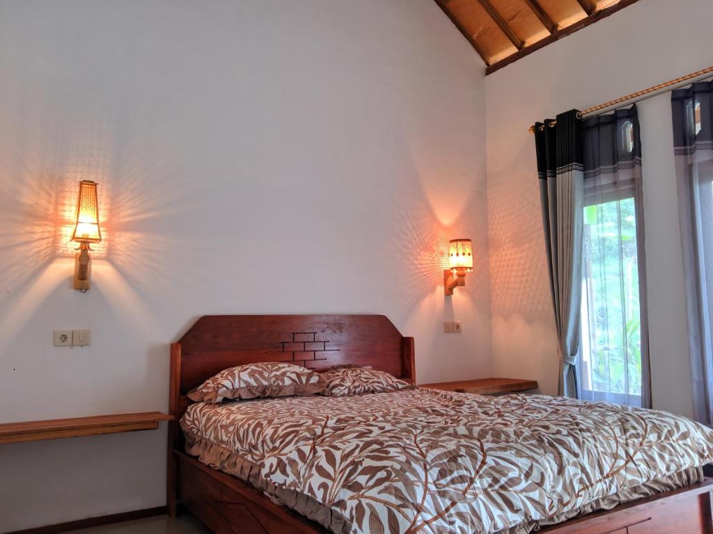 特特巴图Sarang Walet Homestay的一间卧室配有一张带两盏灯的床和一扇窗户。