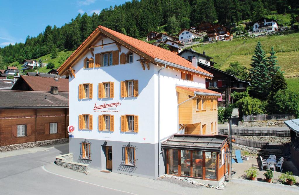 RuscheinBoardercamp Laax - swiss mountain hostel的街道上带窗户的大型白色建筑