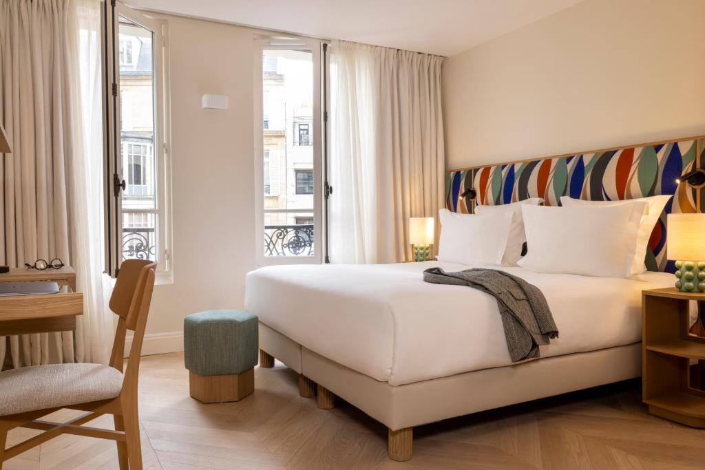 巴黎Padam Hôtel的卧室设有一张白色大床和一扇窗户。