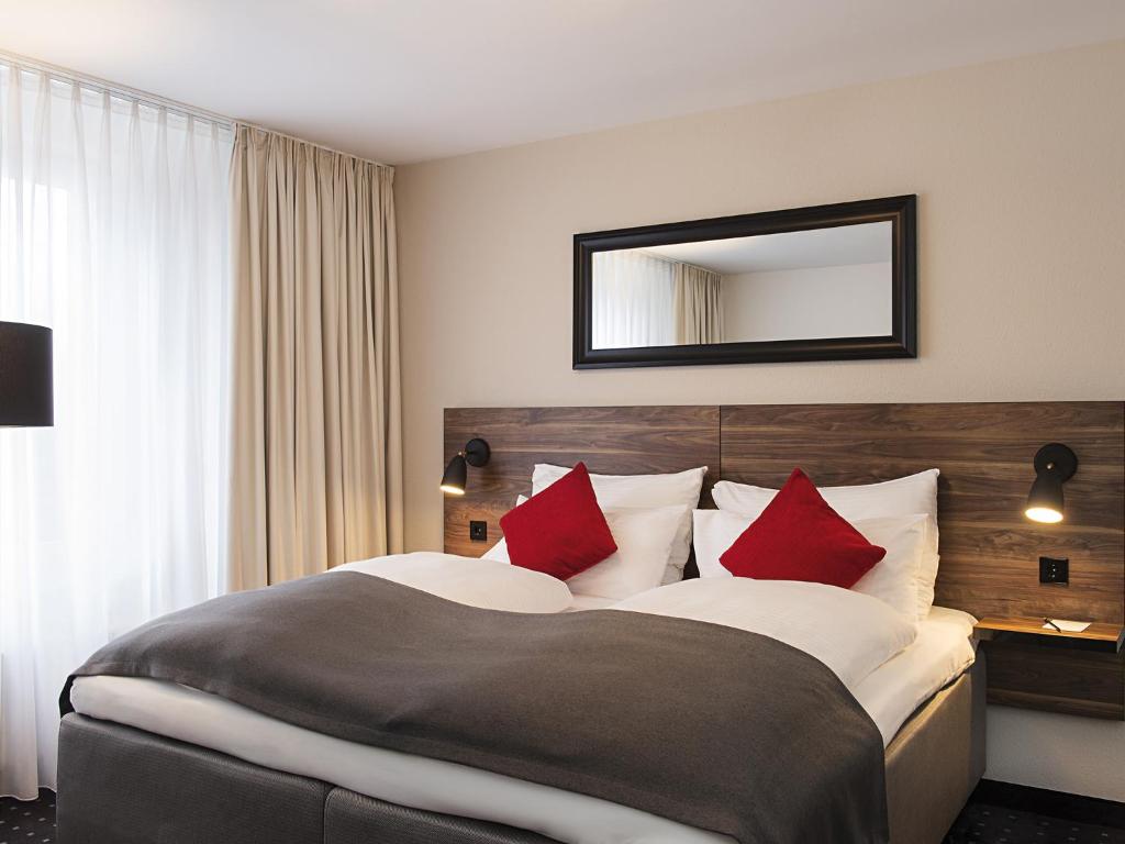 乌特斯克雷斯海姆慕尼黑维克多酒店的酒店客房配有一张带红色枕头的大床