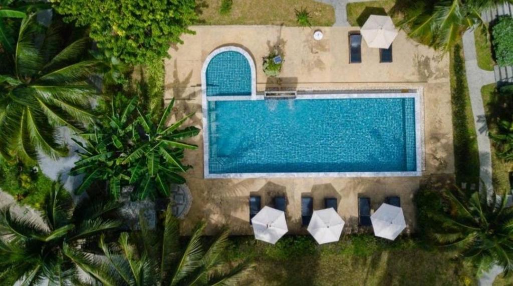蔻立Grandfather Khaolak Resort的房屋旁带椅子的游泳池的顶部景色