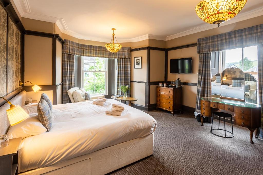 因纳利森Traquair Arms Hotel的卧室配有一张白色大床和一张书桌