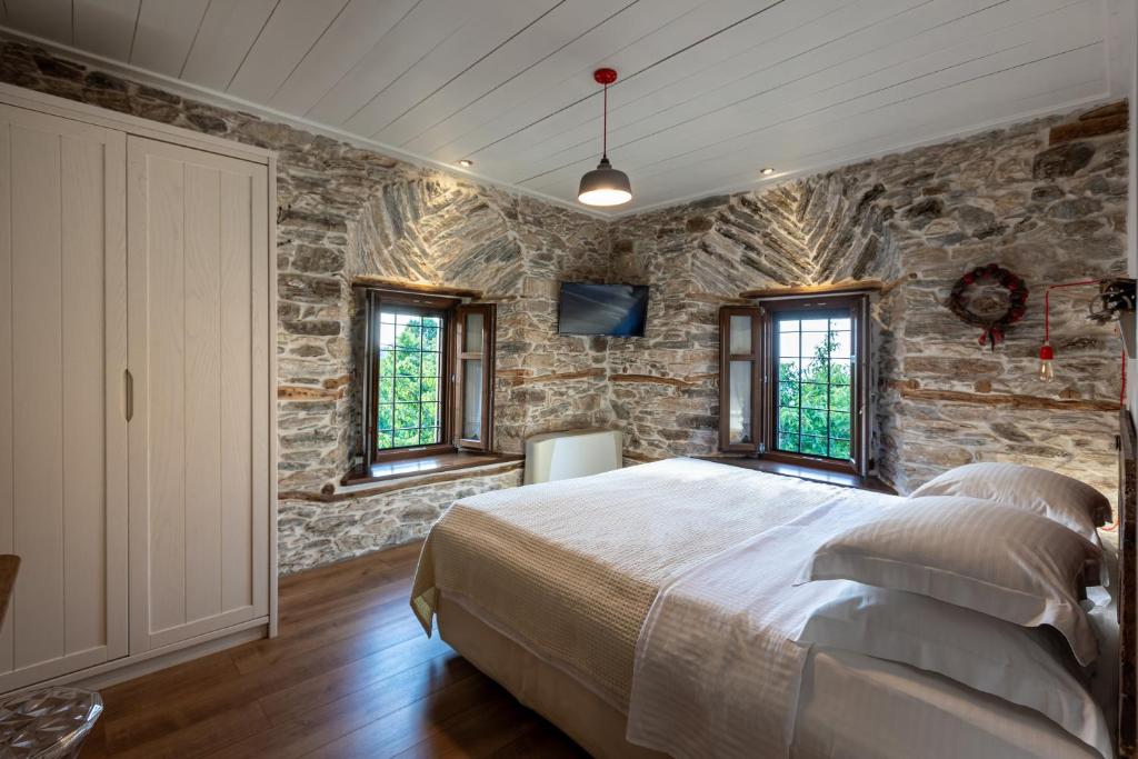 莫雷逊山之秘旅馆的石墙卧室配有床和窗户