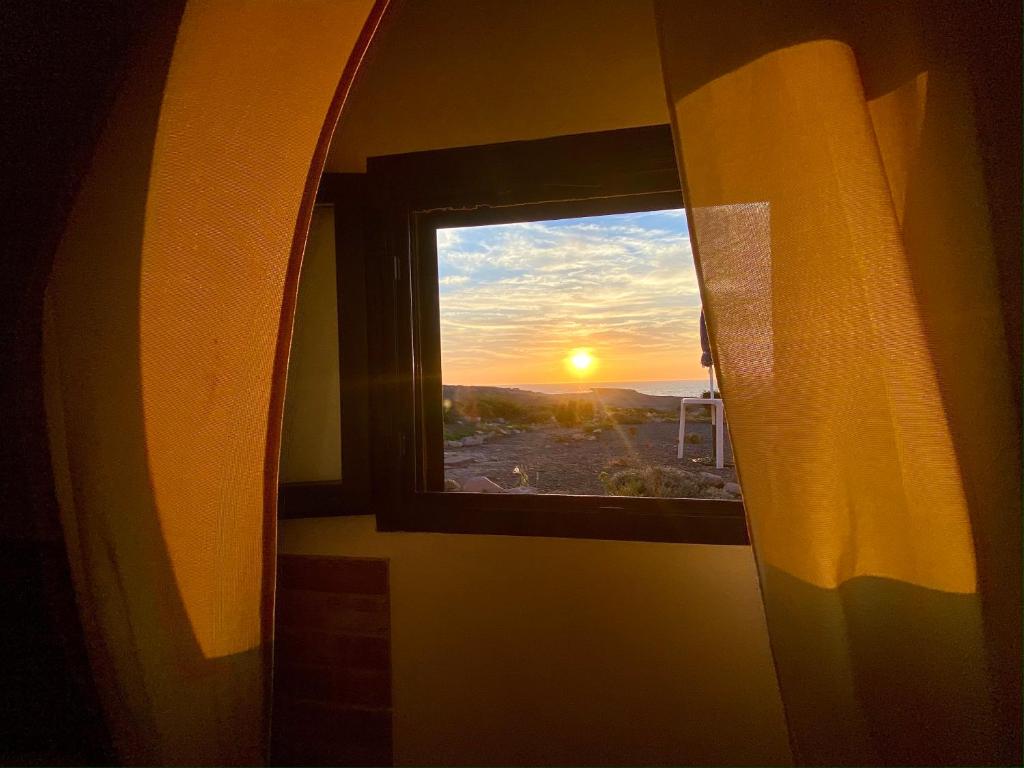 卡洛福泰Guest House Calalunga Scogliera的享有日落美景的窗户
