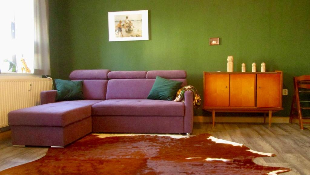 艾本施托克Ferienwohnung Ida Pfeiffer的客厅配有紫色沙发和绿色墙壁