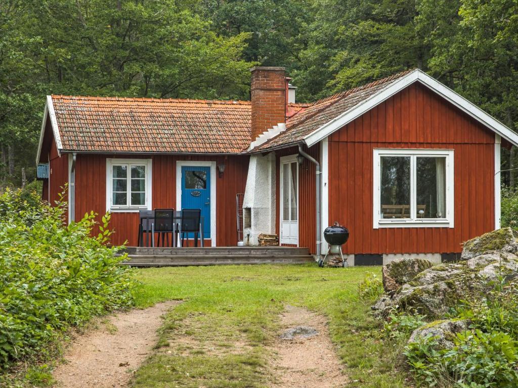 EringsbodaChalet Ängsjömåla by Interhome的一间红色的小房子,带蓝色门