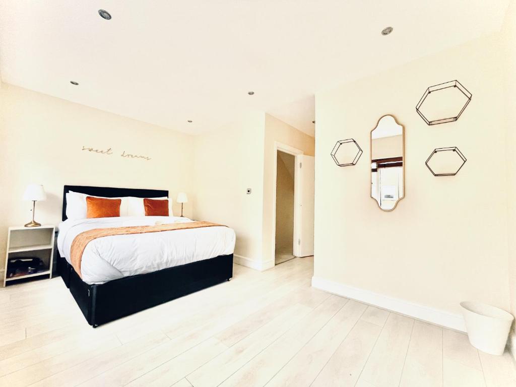 伦敦Islington Town House的白色的卧室设有一张床和带镜子的墙壁