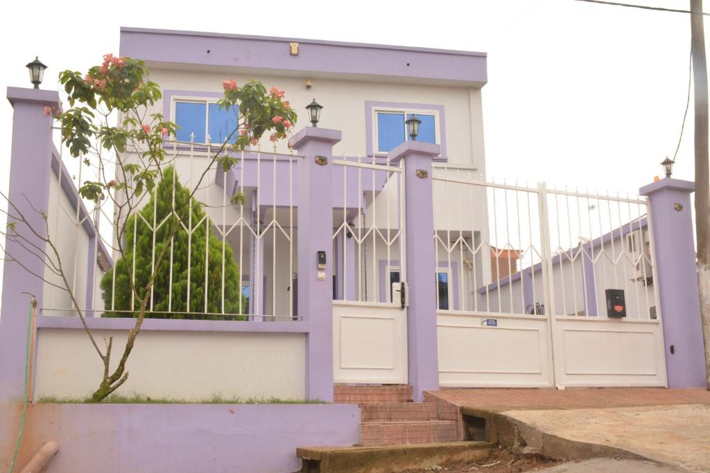 杜阿拉Polgaro duplex luxueux的紫色栅栏和门的房子