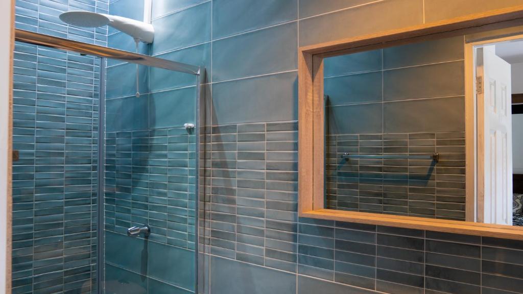 戴维Doral Executive Apartments的浴室设有玻璃淋浴间和镜子