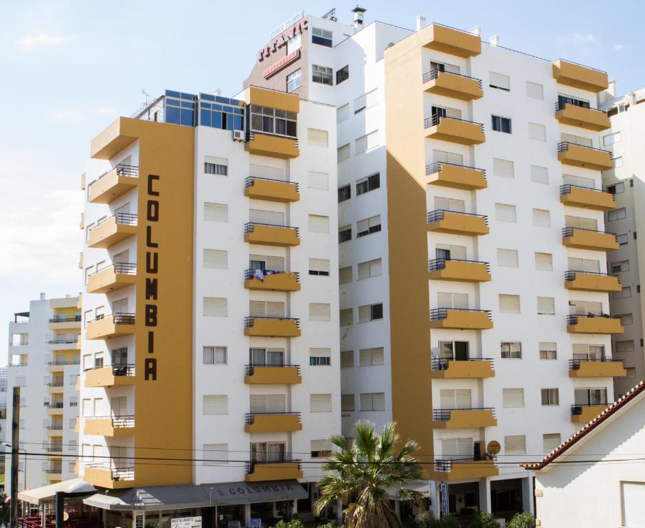 波尔蒂芒图瑞斯提科哥伦比亚公寓酒店的一座高大的白色建筑,设有黄色的阳台