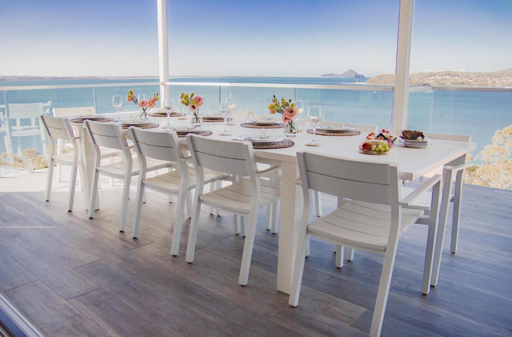 萨拉曼德湾Bluewater Splendour - Heated infinity pool and amazing views!!的阳台设有白色用餐室、桌椅