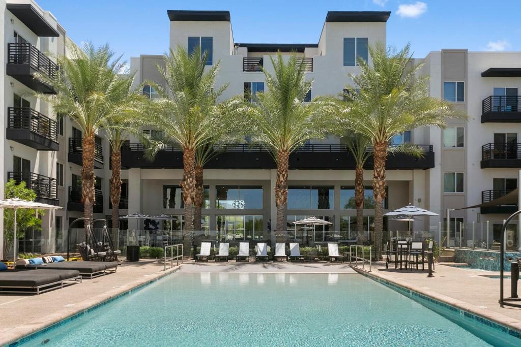 斯科茨Premium One and Two Bedroom Apartments at Slate Scottsdale in Phoenix Arizona的一座楼前棕榈树游泳池