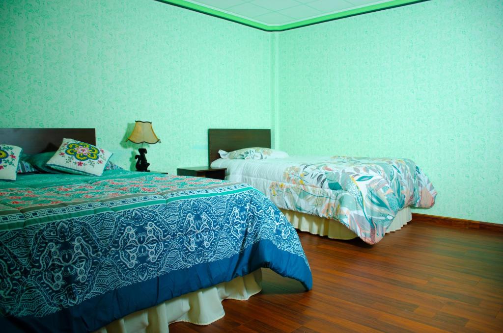 乌尤尼HOSTAL SALARCITO的一间卧室设有两张床,铺有木地板