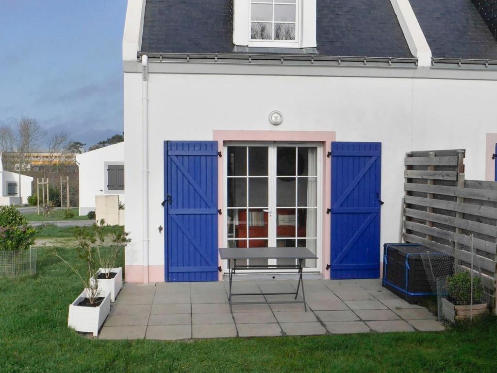勒帕莱Maison Le Palais, 3 pièces, 4 personnes - FR-1-418-220的一座带蓝色门和天井长凳的房子