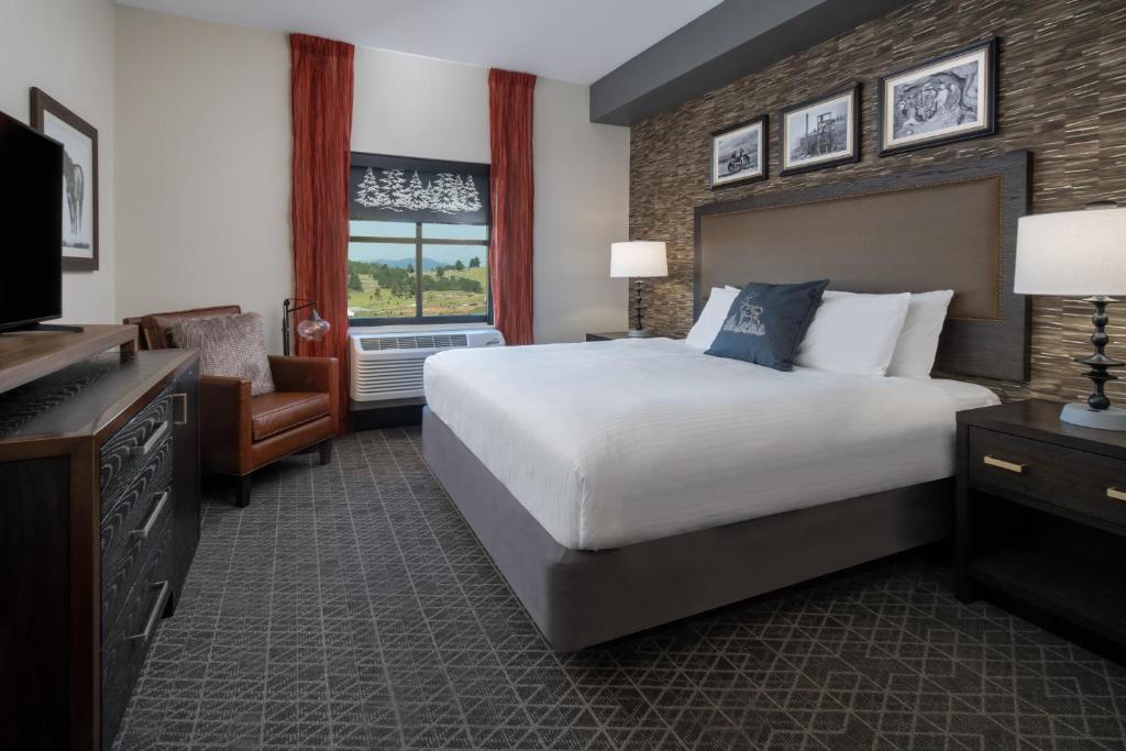 克里普尔克里克Golden Nugget & Gold King Mountain Inn的酒店客房设有一张大床和一台电视。