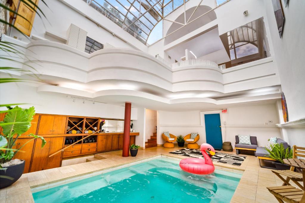 奥斯汀The Graeber by Lodgewell - 6th St & Pool的一个带粉色天鹅的室内游泳池,位于一个天花板的房间