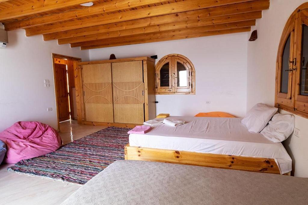 达哈布Marine Garden Camp的一间带两张床的卧室,位于木天花板的房间