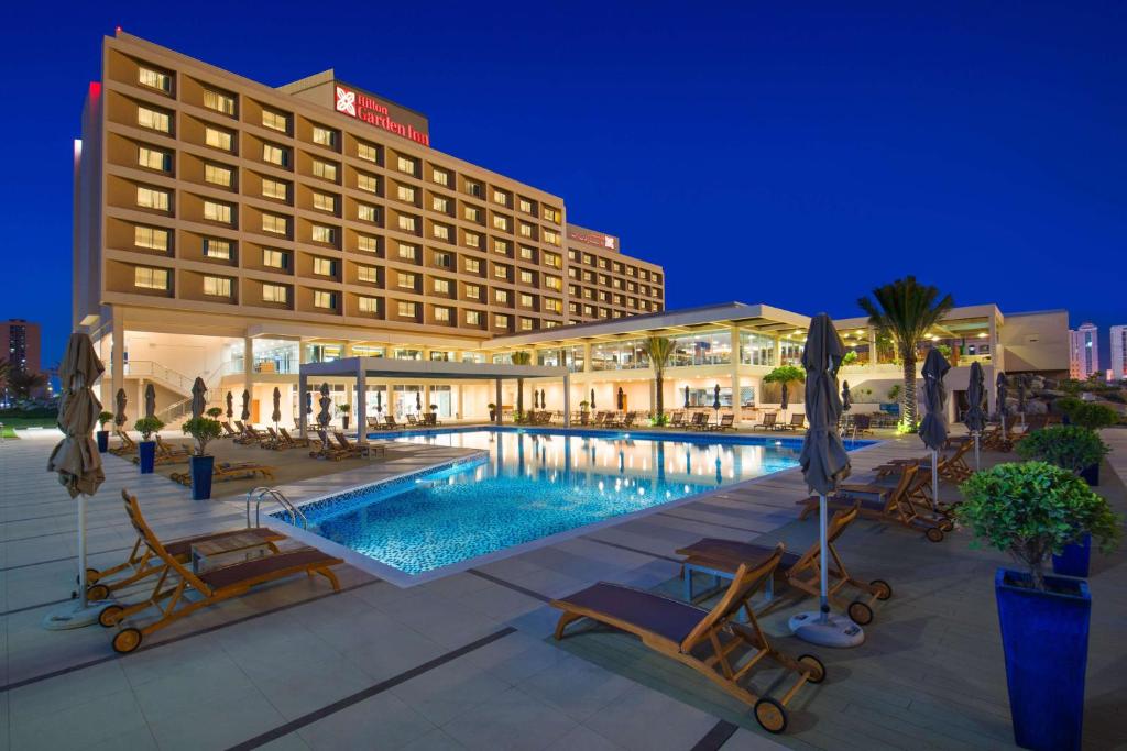 拉斯阿尔卡麦希尔顿哈伊马角酒店的夜间设有游泳池的酒店