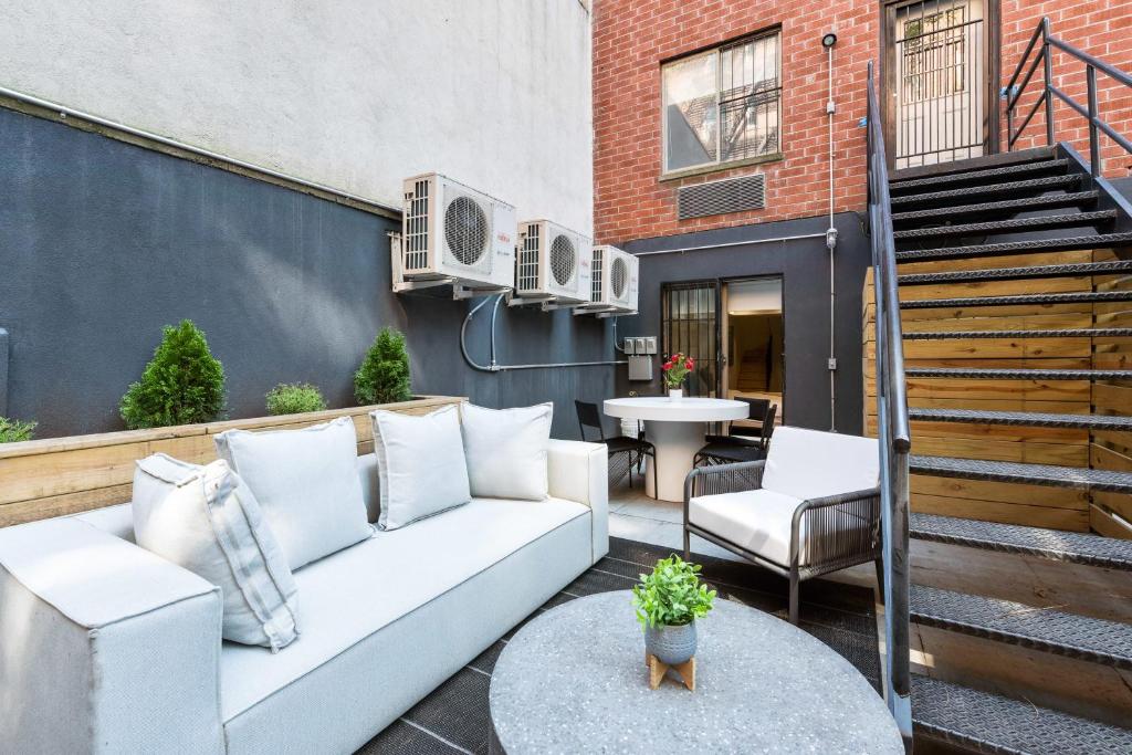 纽约Unbeatable 3BR with Private Patio in Upper East Side的庭院配有白色的沙发和桌子