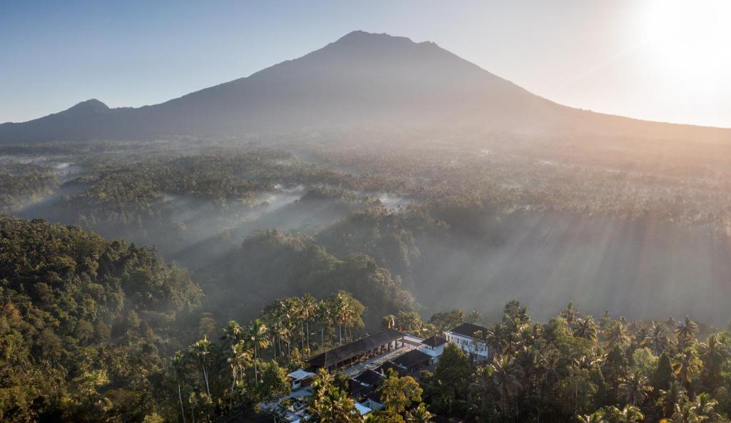 MenangaTapa Agung View的享有山丘的景色,背景是高山