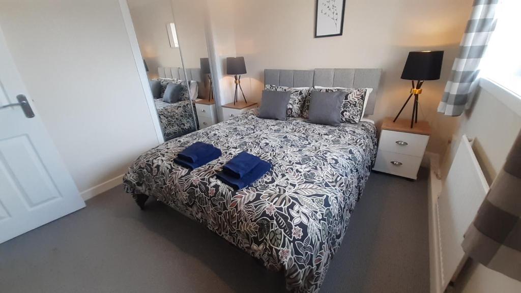 罗塞斯Carvetii - Clark House - Spacious ground floor flat的一间卧室配有一张带蓝色床单和枕头的床。