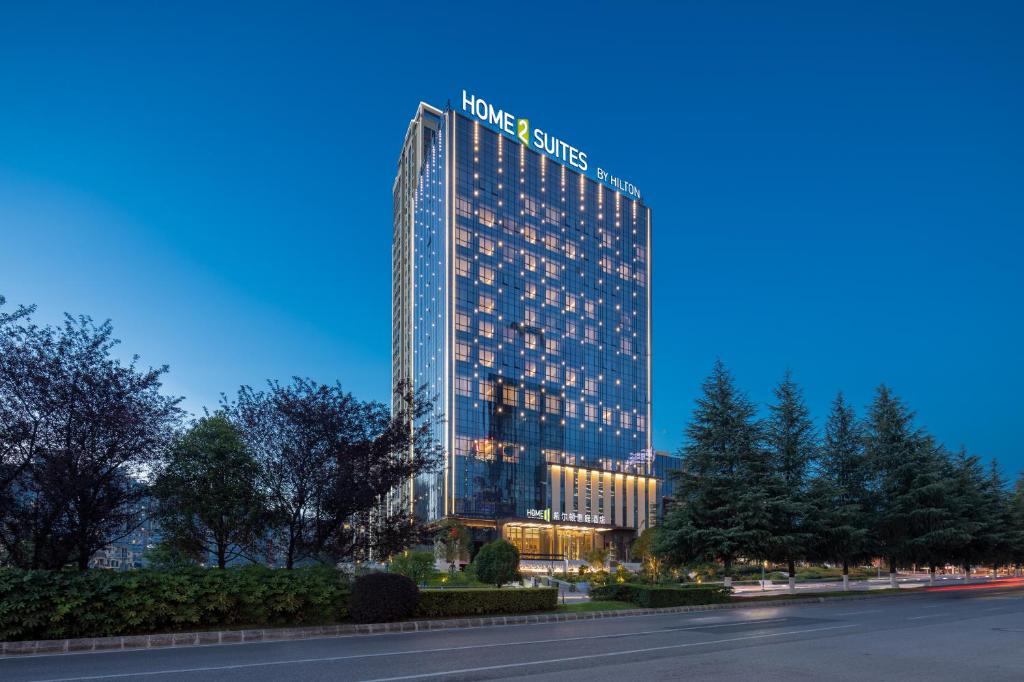 贵阳Home2 Suites by Hilton Guiyang Guanshanhu的一座有灯的建筑,上面有标志