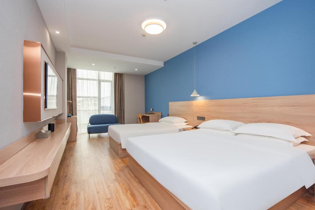 上海上海未来上居酒店的一间卧室设有两张床和蓝色的墙壁