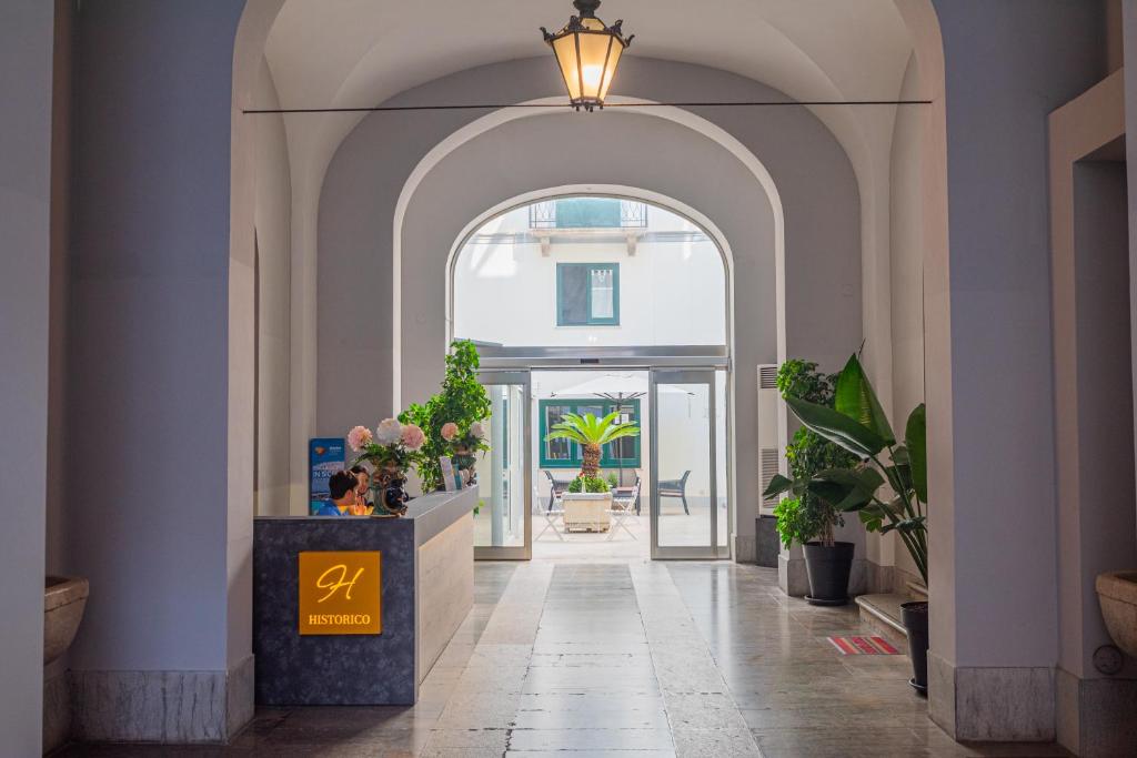 特拉帕尼Historico Loft & Rooms Palazzo Adragna XIX的拱形走廊,入口处有植物