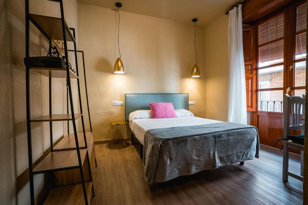 格拉纳达Veronica Centro的一间卧室配有一张带粉红色枕头的床