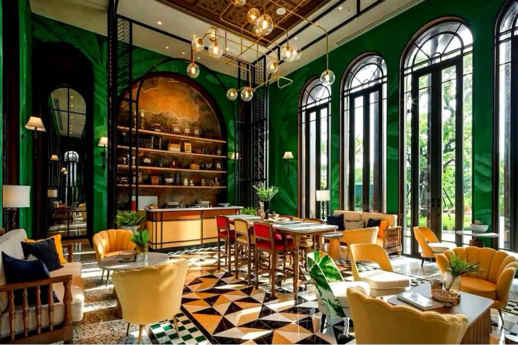 华欣Lahabana Resort的餐厅拥有绿色的墙壁和桌椅