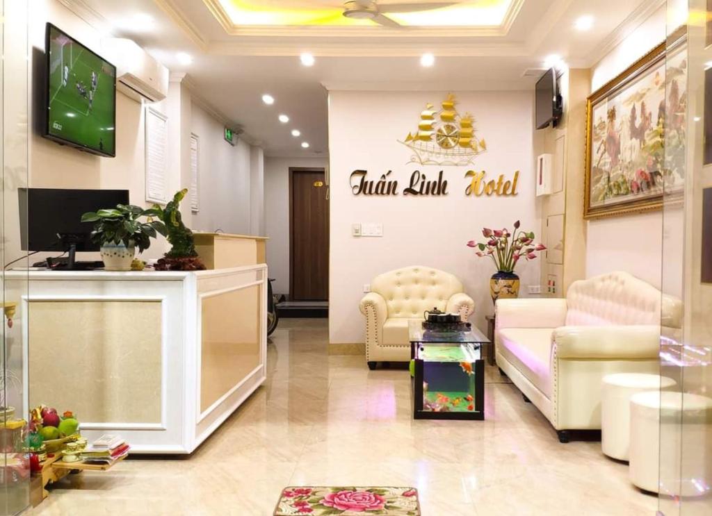 下龙湾Tuấn Linh Hotel的一个带电视和椅子的候机室的沙龙