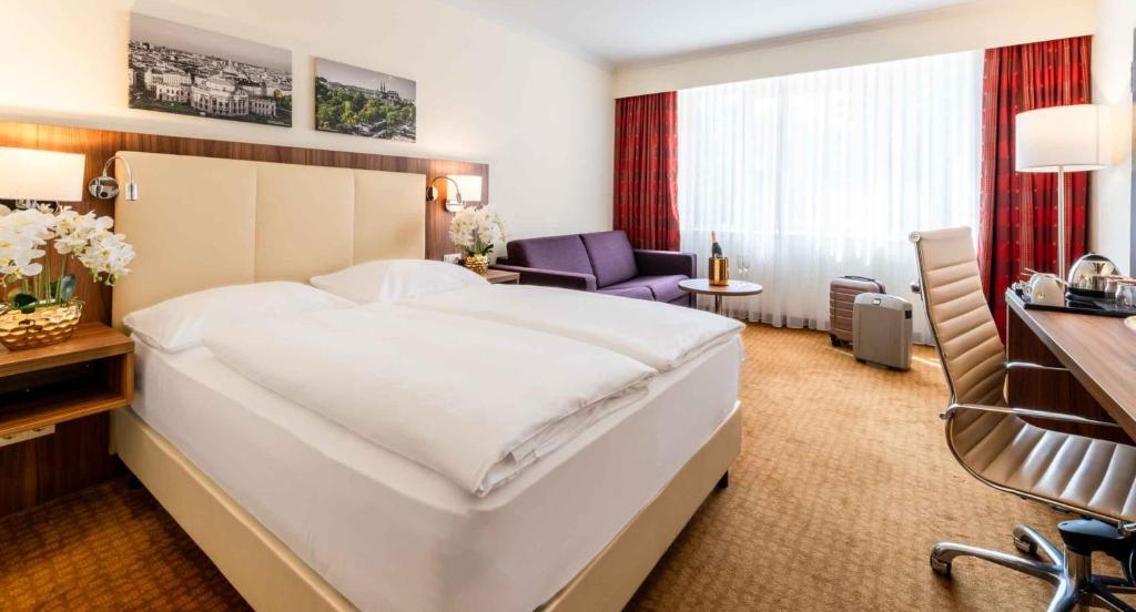 维也纳PLAZA Premium Wien的酒店客房设有一张大床和一张书桌。