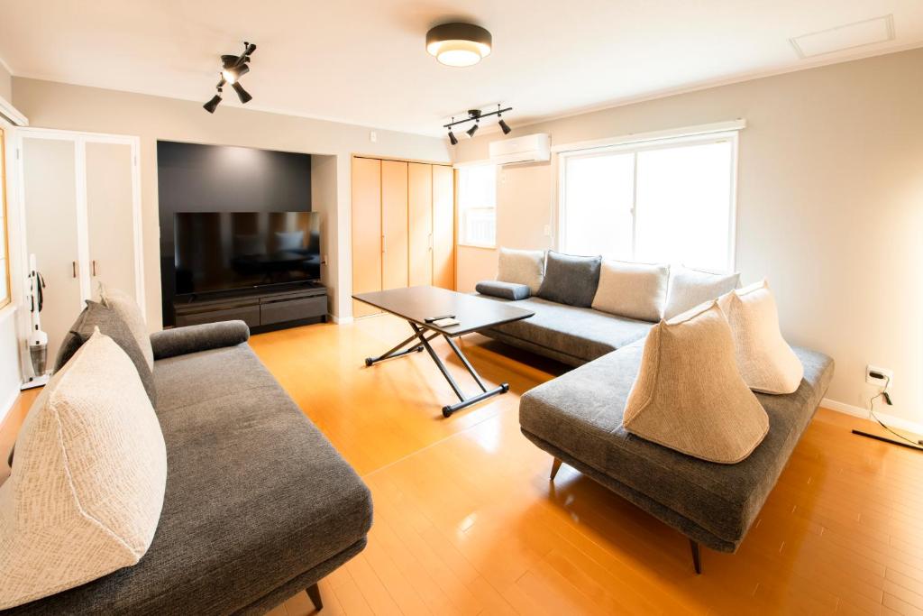 函馆Villa Futaba若松町的客厅配有两张沙发和一台电视