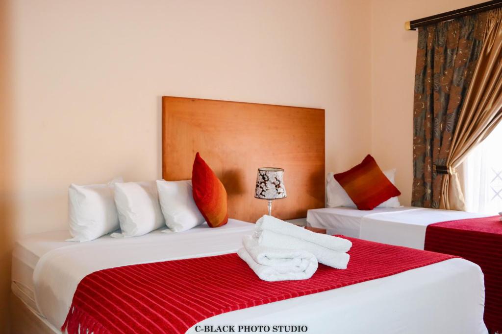 NqutuMeet Mekaar Resorts - Nquthu Hotel的两张位于酒店客房的床,配有毛巾