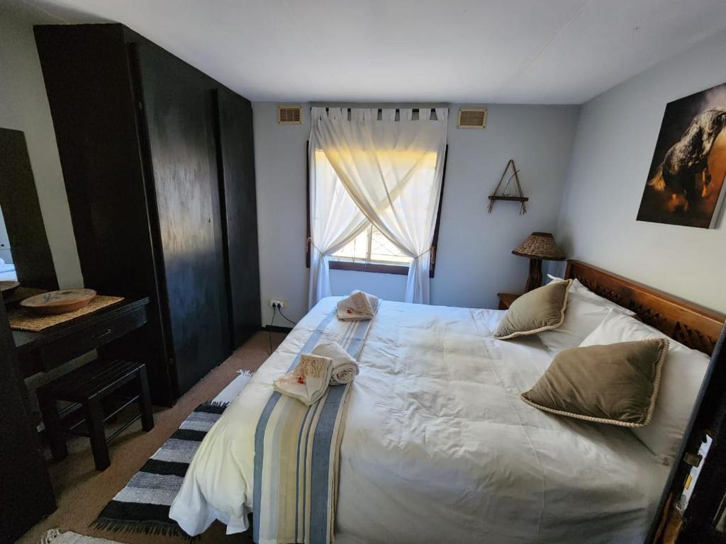 伊丽莎白港Heavenly Stables Self Catering Accommodation的一间卧室设有一张大床和一个窗户。