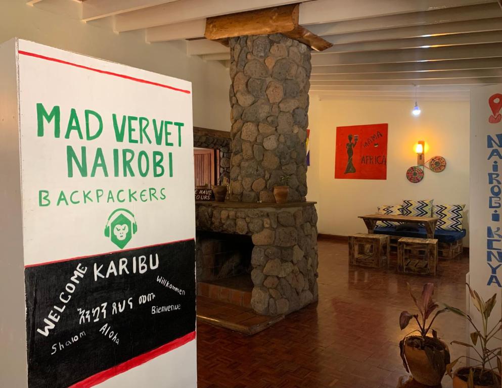 内罗毕Mad Vervet Nairobi Backpackers Hostel的客厅的石制壁炉上的标志