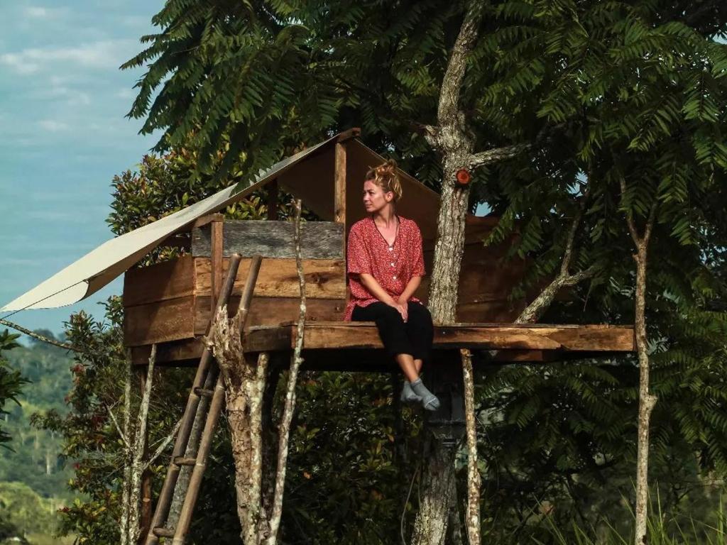 Tree House的坐在树屋顶上的女人