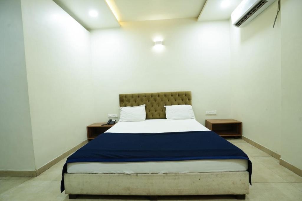 戈尔哈布尔Hotel Anand的一间卧室配有一张带蓝色毯子的大床