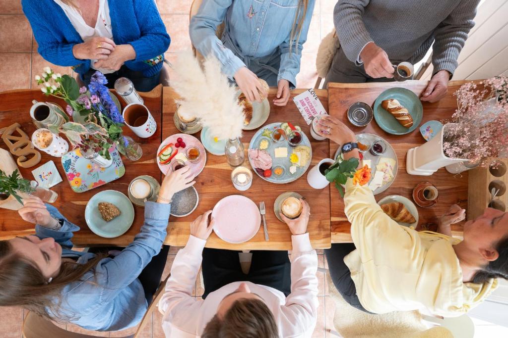 圣彼得奥尔丁Hotel 'Das Strandhaus'的一群坐在桌子旁吃食物的人