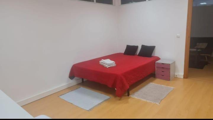 莱里亚Centro Leiria的一间卧室配有红色的床和两个枕头
