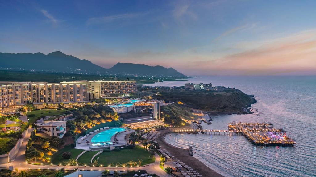 凯里尼亚Elexus Hotel Resort & Spa & Casino的夜间享有度假胜地和海洋的空中景色
