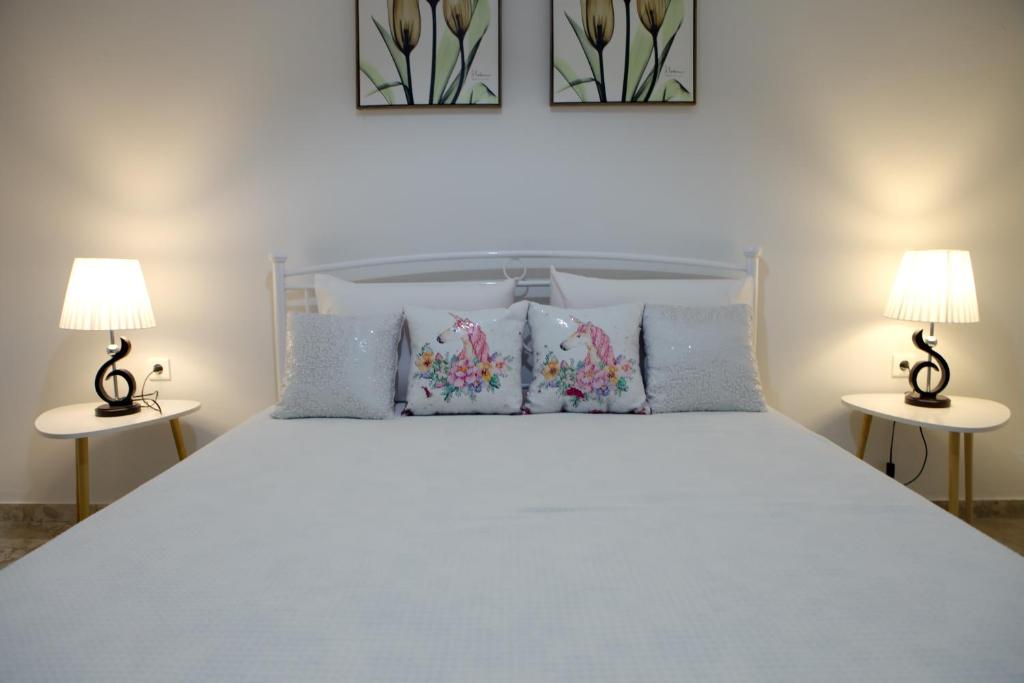 纳夫普利翁Didis Place Nafplio的一间卧室配有一张带两盏灯的大型白色床。