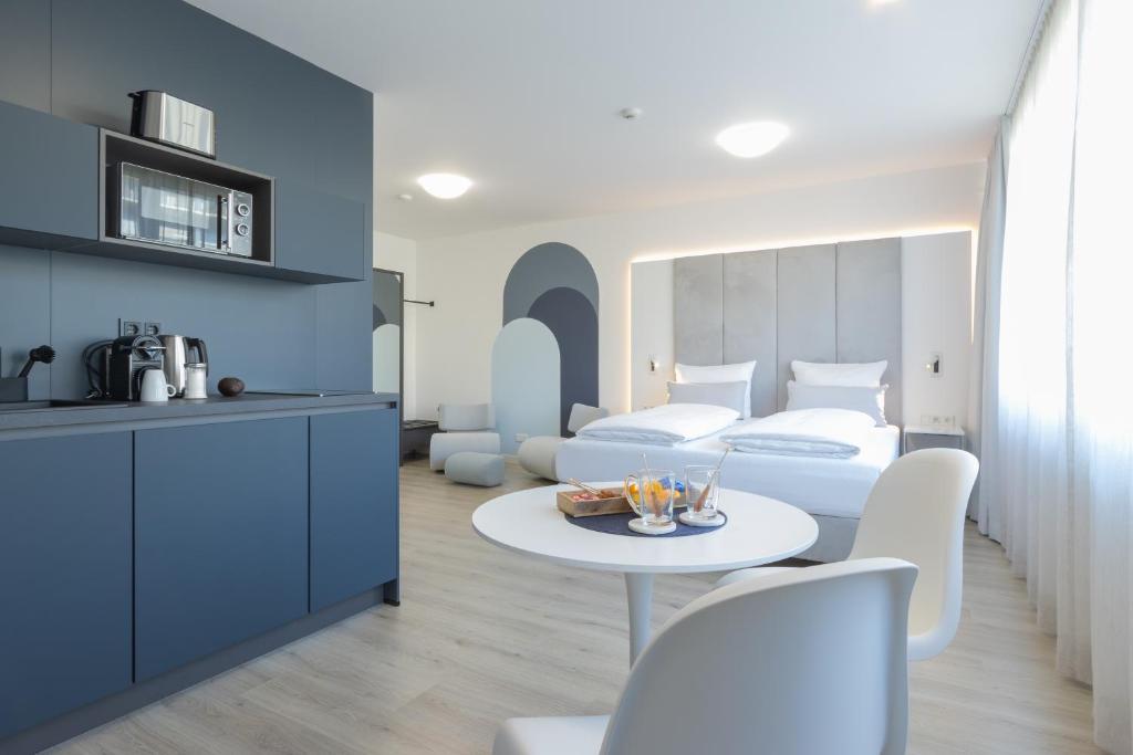 比勒费尔德zzzpace Smart-Hotel Bielefeld Zentrum的卧室配有一张床和一张桌子及椅子