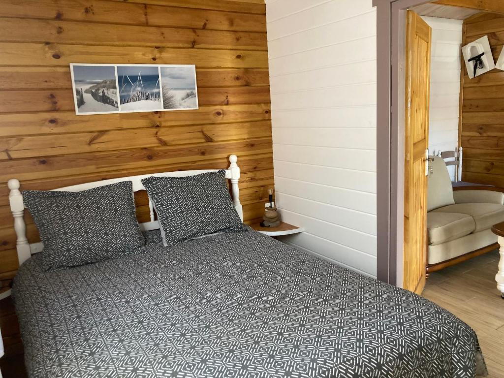 勒泰克Chalet的一间卧室设有一张床和木墙