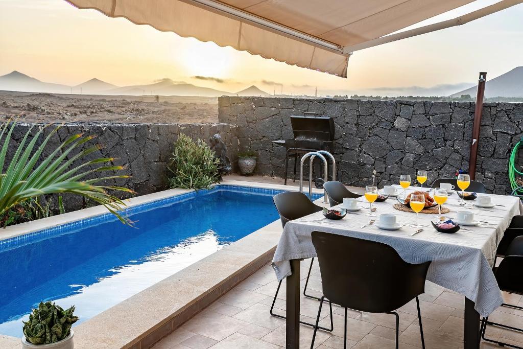 特吉塞Villa LanzaCosta Golf的游泳池旁的餐桌和椅子