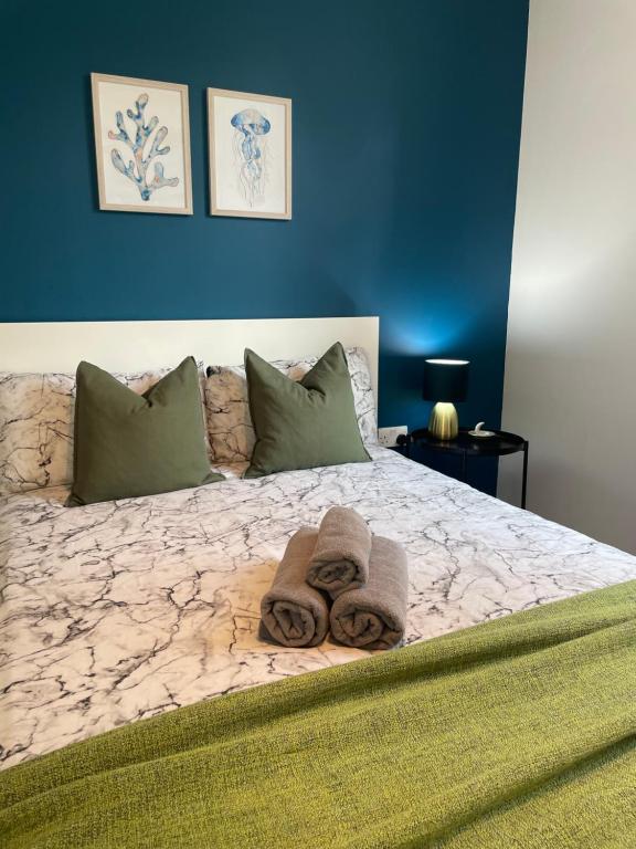 伦敦Willesden Green ROOMS的一间卧室配有一张大床和毛巾