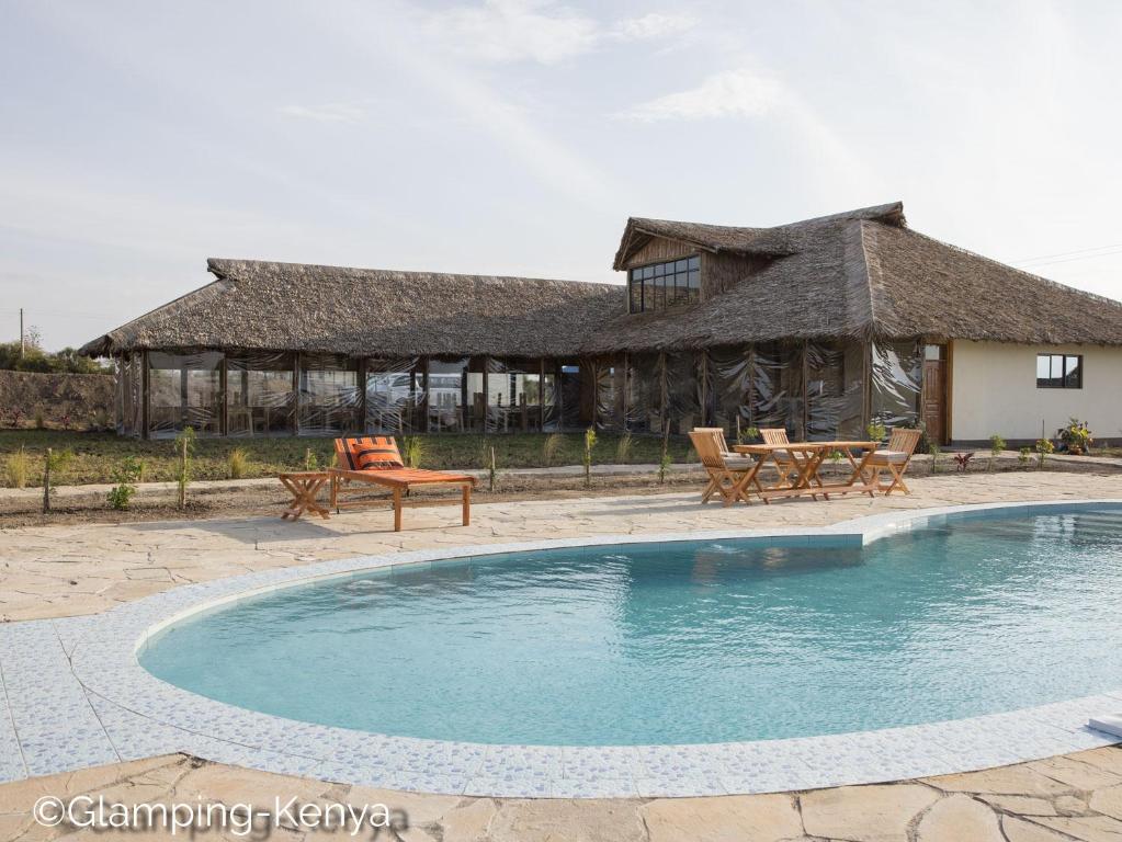 Naro MoruGlamping Kenya Mt. Kenya Lodge的一个带游泳池和房子的度假胜地